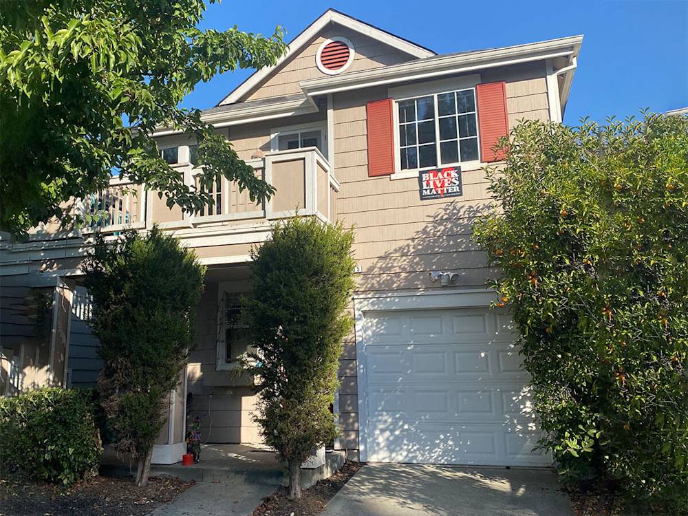 Worn exterior siding with beige color and outdated red shutters in Petaluma