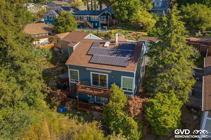 Modern home exterior in Oakland with James Hardie Plank siding, solar panels, and surrounding greenery