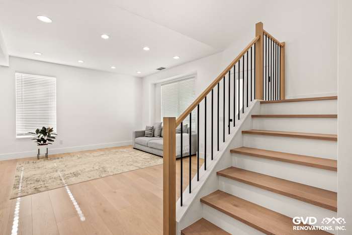 Modern staircase with wooden treads and black metal railing in a bright living space, Antelope home remodel