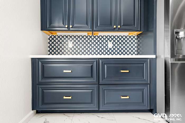 Navy blue kitchen cabinets with gold hardware and a diamond-patterned backsplash in Sacramento remodel