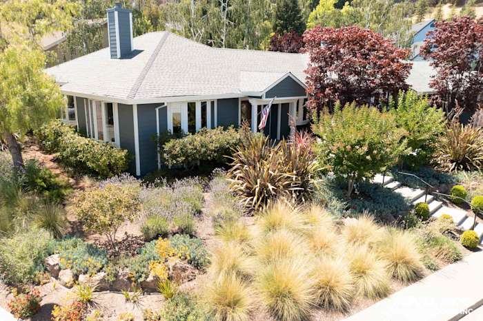 Home exterior featuring James Hardie Evening Blue lap siding with Arctic White trim and landscaped garden