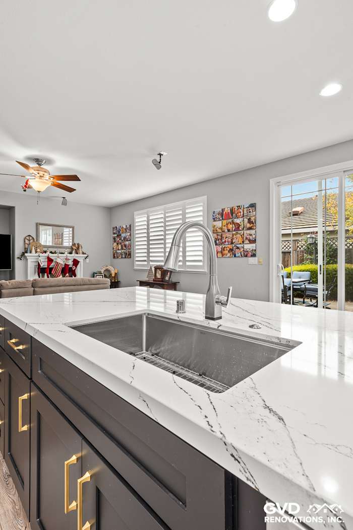Elegant kitchen remodel featuring Cambria custom countertops, dark cabinetry, and modern stainless steel sink in Roseville