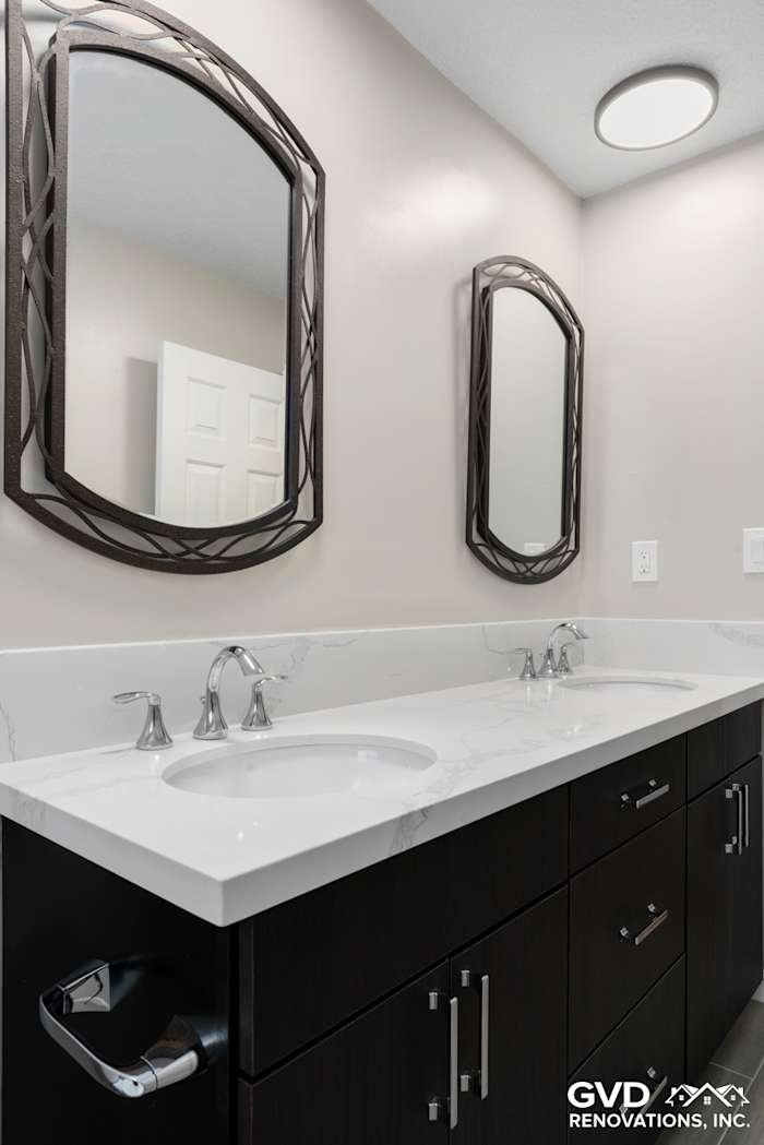 Modern bathroom with dual sinks, dark wood cabinetry, and framed mirrors in Rocklin, CA