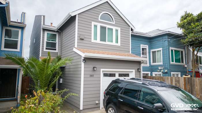 Home exterior featuring Aged Pewter James Hardie siding, Arctic White trim, and modern garage with SUV parking