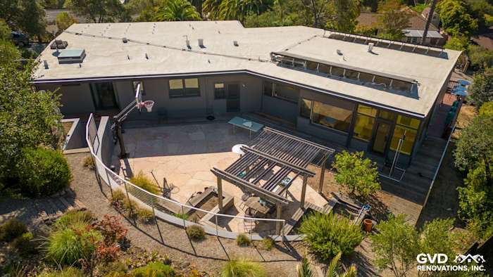 Home exterior showing newly installed James Hardie plank lap siding in Night Gray with a landscaped patio