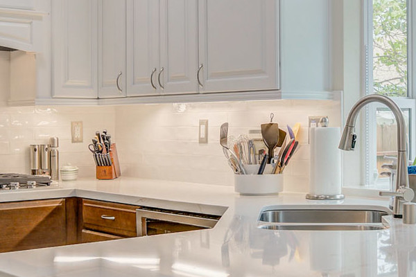 Modern kitchen remodel with white cabinetry, quartz countertop, stainless steel appliances, and large window in Elk Grove
