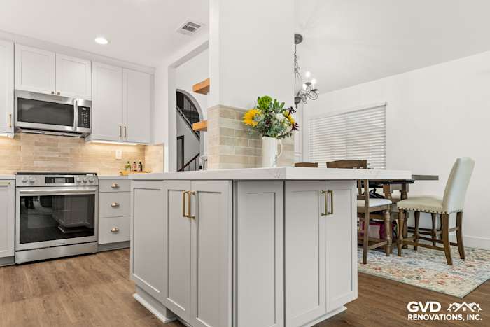 Modern kitchen remodel featuring Waypoint Painted Harbor cabinetry, Vadara Naurelle stone island, and MSI Brickstone Ivory