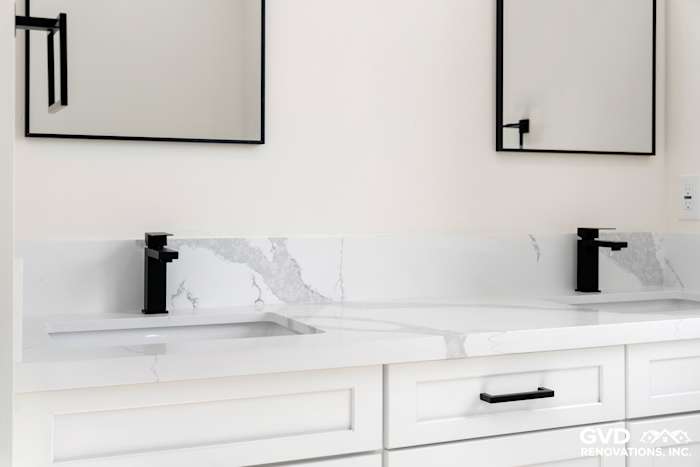 Sleek bathroom vanity with white quartz countertop, black faucets, and modern mirrors in Paradise, CA home