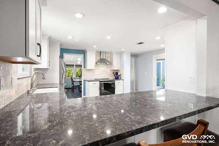 Modern kitchen in Fair Oaks, featuring dark quartz countertops, white cabinetry, and stainless steel appliances
