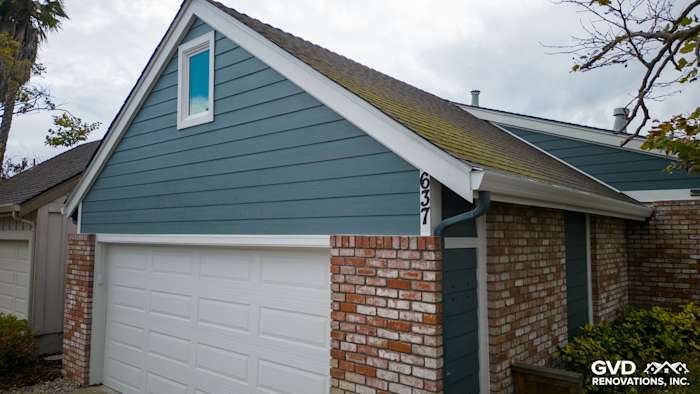 Evening Blue James Hardie siding with Arctic White trim on Alameda home exterior, showcasing garage and roofline