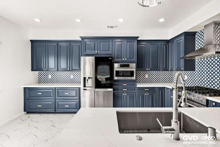 Modern kitchen remodel featuring navy blue cabinets, white quartz countertops, and patterned backsplash in Sacramento