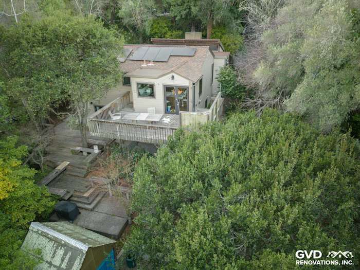 Aerial view of a remodeled Oakland home with James Hardie siding, surrounded by lush greenery and a wooden deck