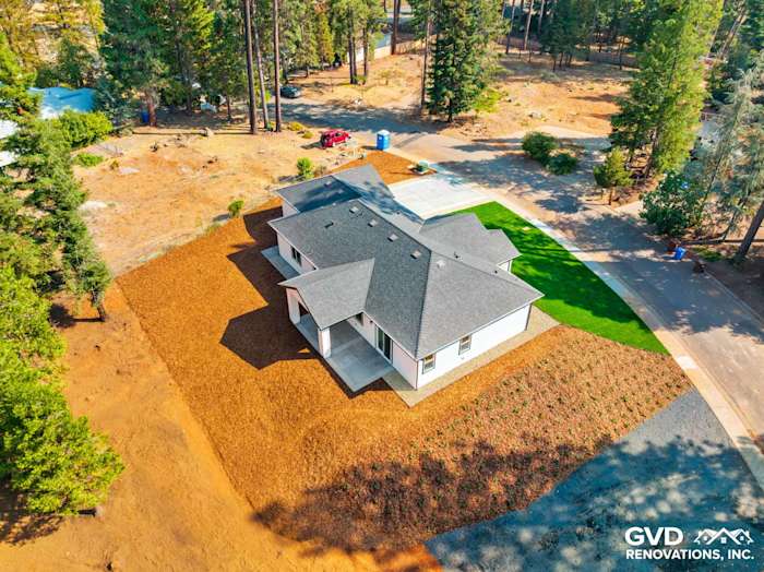 Aerial view of a new construction home in Paradise, CA, featuring a dark gray roof and landscaped yard