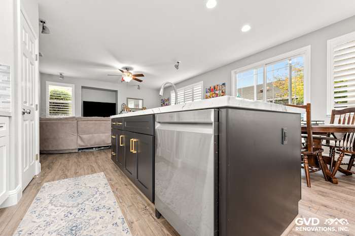 Modern kitchen with Cambria custom countertops, dark cabinets, and an island featuring a stainless steel sink