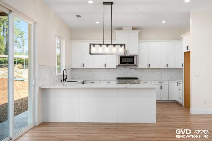 Bright modern kitchen featuring white cabinets, quartz countertops, and a stylish pendant light in Paradise, CA
