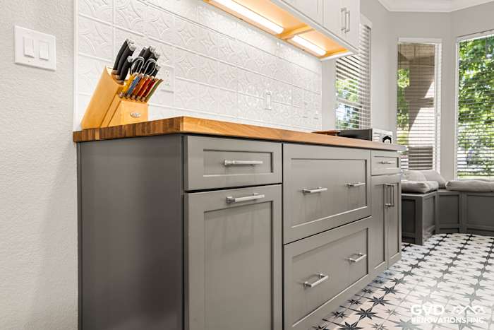 Sleek gray cabinetry with wooden countertop, modern knife block, and patterned floor in remodeled Folsom kitchen