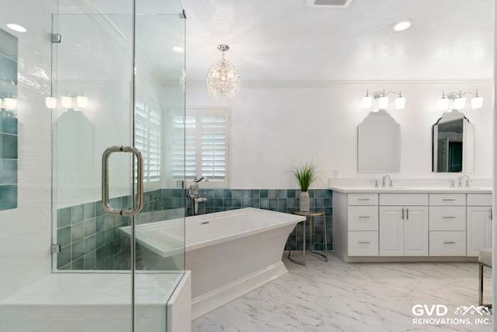 Bright bathroom with glass shower, freestanding tub, white cabinetry, and blue-green backsplash tiles in Fair Oaks