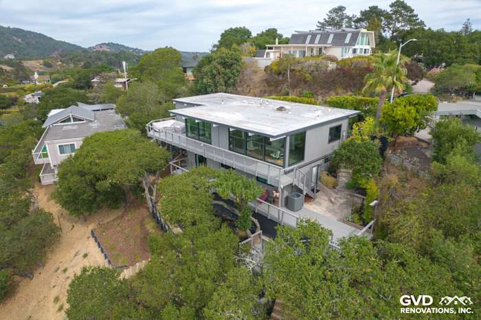 Modern San Rafael home featuring new T1-11 siding, large windows, and overlooking hillside views