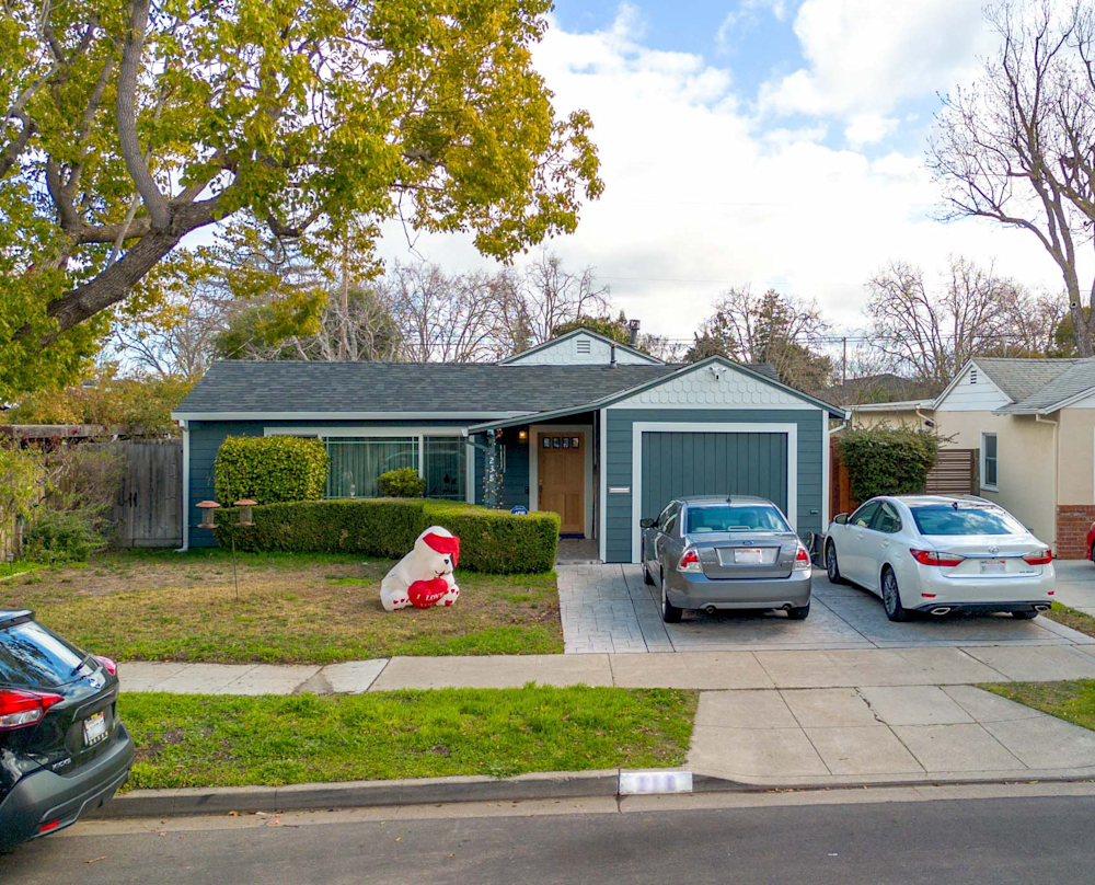 Updated home facade featuring fresh paint, neat landscaping, and a modern garage door
