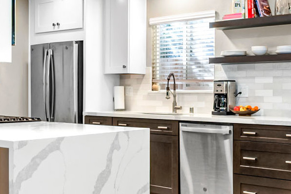Modern kitchen remodel featuring quartz countertops, dark cabinetry, and an open dining area in Davis, CA