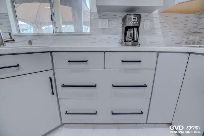 Modern kitchen remodel featuring sleek white cabinetry and black drawer pulls in Sacramento