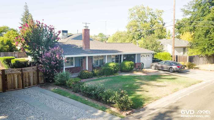 Home exterior featuring Boothbay Blue James Hardie siding, Arctic White trim, and lush landscaping in Sacramento
