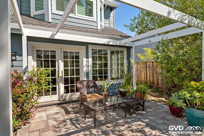 Patio area featuring a modern table and chairs, surrounded by greenery and Hardie siding in Boothbay Blue