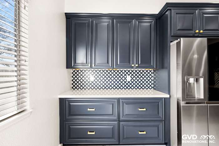 Navy blue kitchen cabinets, white quartz countertop, and stylish backsplash in Sacramento remodel