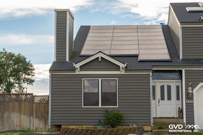 New Prodigy Siding in dark gray installed on home's exterior with solar panels and landscaped front yard