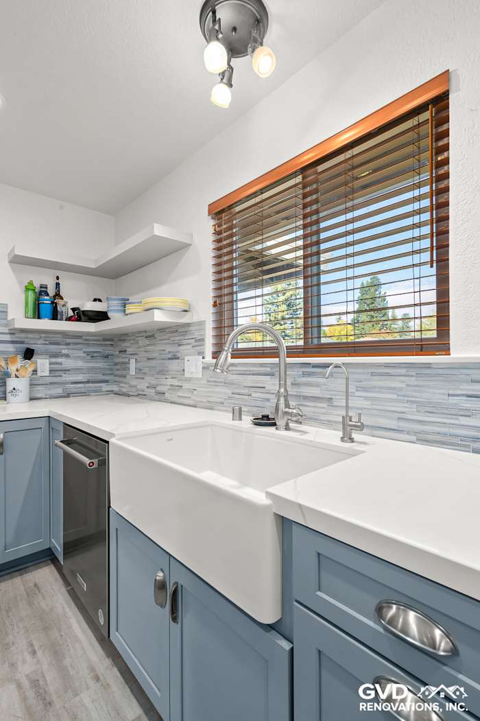 Modern kitchen with gray Waypoint cabinets, white farmhouse sink, and Misty Fjord Linear backsplash in Elk Grove