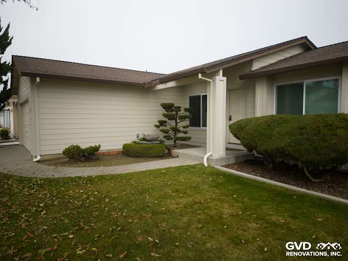 James Hardie Navajo Beige Lap Siding on a home's exterior, featuring trimmed shrubs and a landscaped entryway