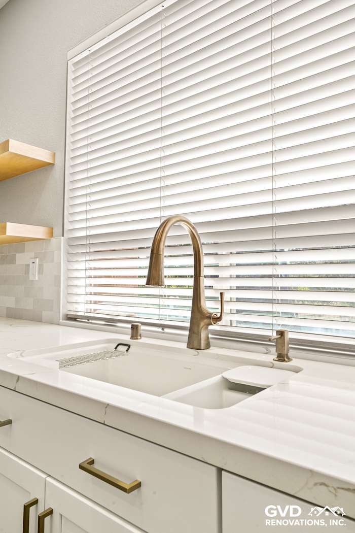 Modern kitchen sink featuring luxurious MSI countertops, Diamond cabinets, and stylish gold faucet in Roseville, CA