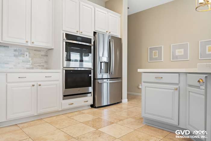 Modern kitchen featuring white cabinets, stainless steel appliances, and beige tile flooring in Sacramento remodel