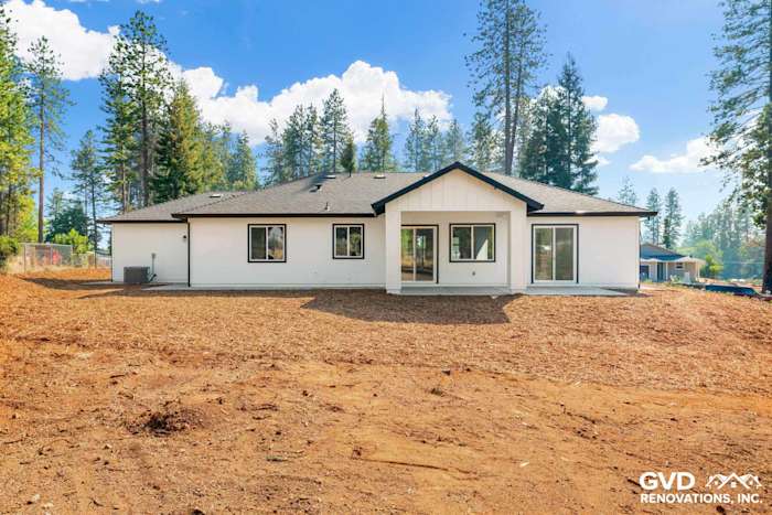 New construction home exterior in Paradise, CA, featuring a modern design, large windows, and natural landscaping