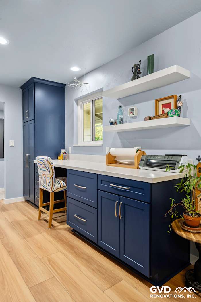 Contemporary kitchen workspace with navy blue cabinets, open shelves, and light wood flooring in Fair Oaks, CA