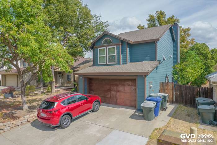 Home exterior in Antelope with newly painted blue James Hardie siding and Anlin Windows, featuring a red SUV in driveway