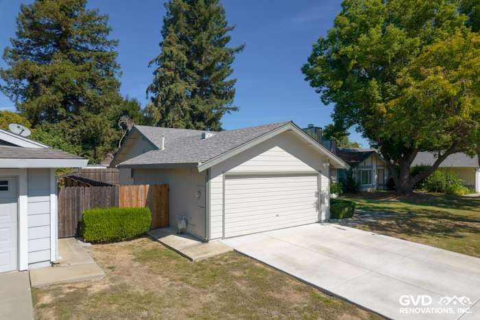 Home exterior showcasing James Hardie siding in light gray with a modern garage and landscaped yard in Sacramento