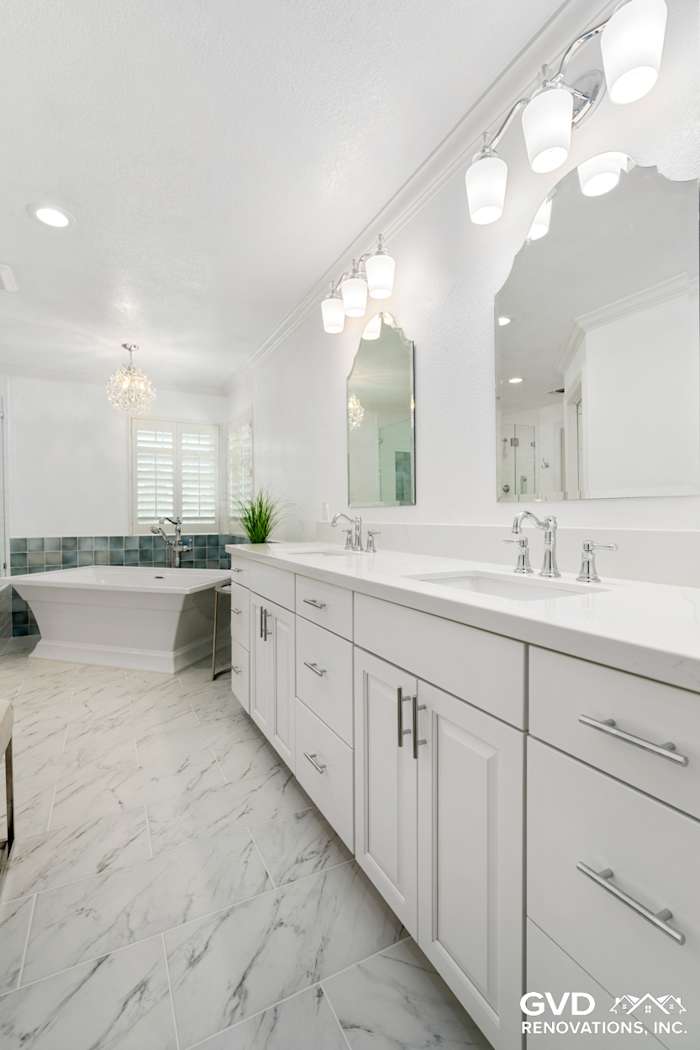Bright bathroom in Fair Oaks featuring a freestanding tub, dual sinks, and modern light fixtures