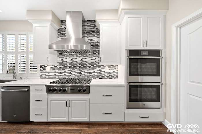 Modern kitchen with white cabinets, stainless steel appliances, and a stylish mosaic backsplash in El Dorado Hills