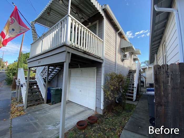 Before view of a home exterior, featuring old siding, garage area, and staircase in Rio Vista