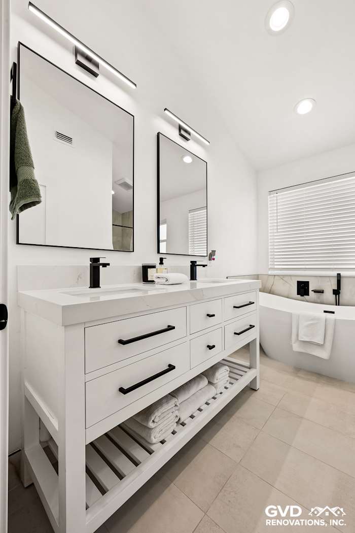 Modern bathroom featuring dual vanities, sleek black fixtures, and a freestanding tub in Antelope, CA