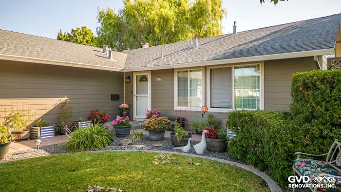 Home exterior featuring Timber Bark HardiePlank siding and Cobble Stone trim, enhanced by colorful flower pots