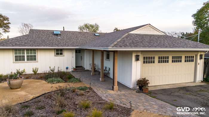 Modern home exterior featuring James HardiePanel Vertical Siding in Arctic White with a stone path and garage