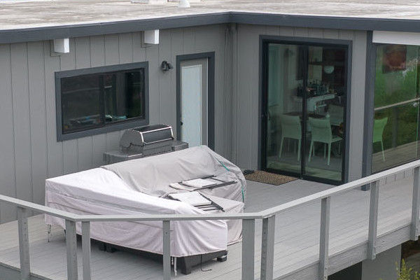 Modern home exterior featuring new T1-11 siding, large windows, and a spacious deck in San Rafael