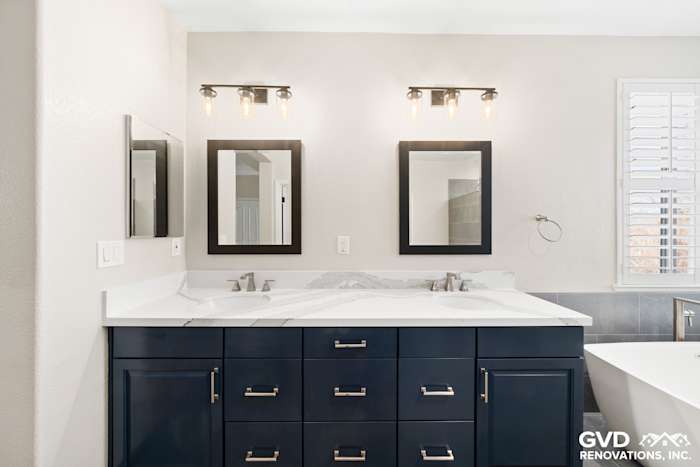 Modern master bathroom with dual sinks, navy cabinetry, and sleek mirrors in El Dorado Hills