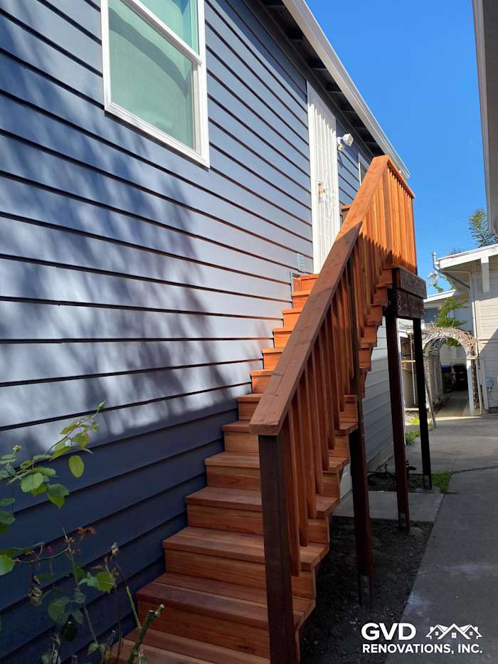 Newly installed CraneBoard vinyl siding in blue with wooden deck and side steps in Rio Vista