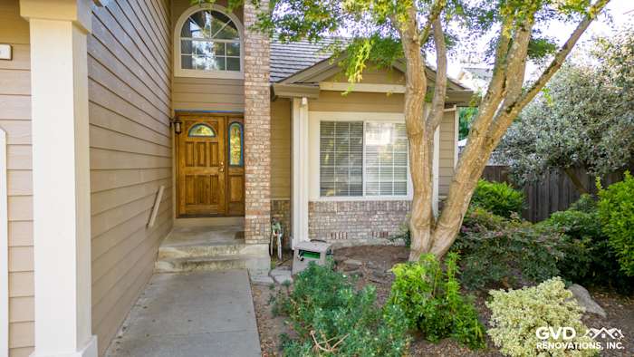 Khaki Brown James Hardie siding and Alside vinyl windows on a Santa Rosa home exterior, featuring a brick entryway