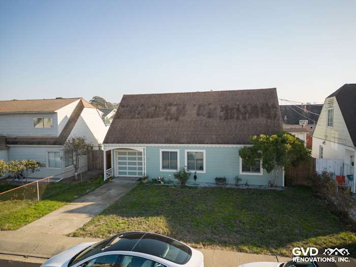 Updated home exterior featuring James Hardie Artisan Lap Siding in light blue, surrounded by a landscaped yard