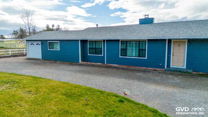 Sonoma home featuring new James Hardie siding in Evening Blue with Arctic White trim and a gravel driveway