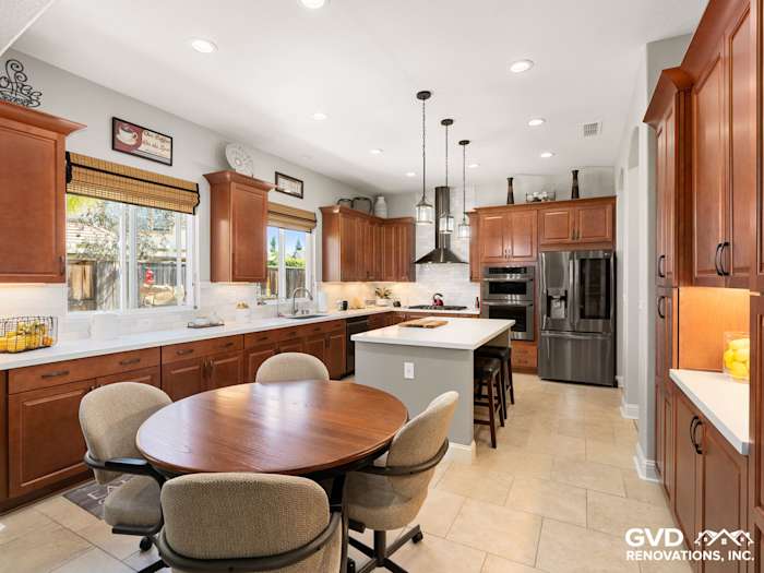 Elegant kitchen remodel featuring dark wood cabinets, quartz countertops, and modern stainless steel appliances in Elk Grove